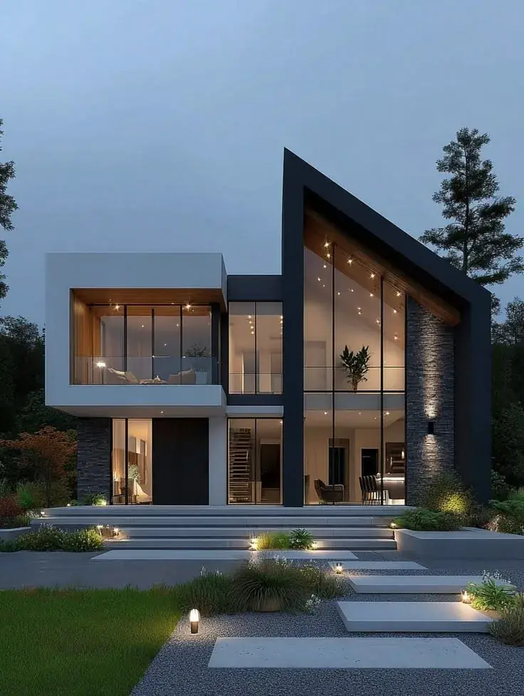 A modern house at dusk, its windows and garden path lit.
